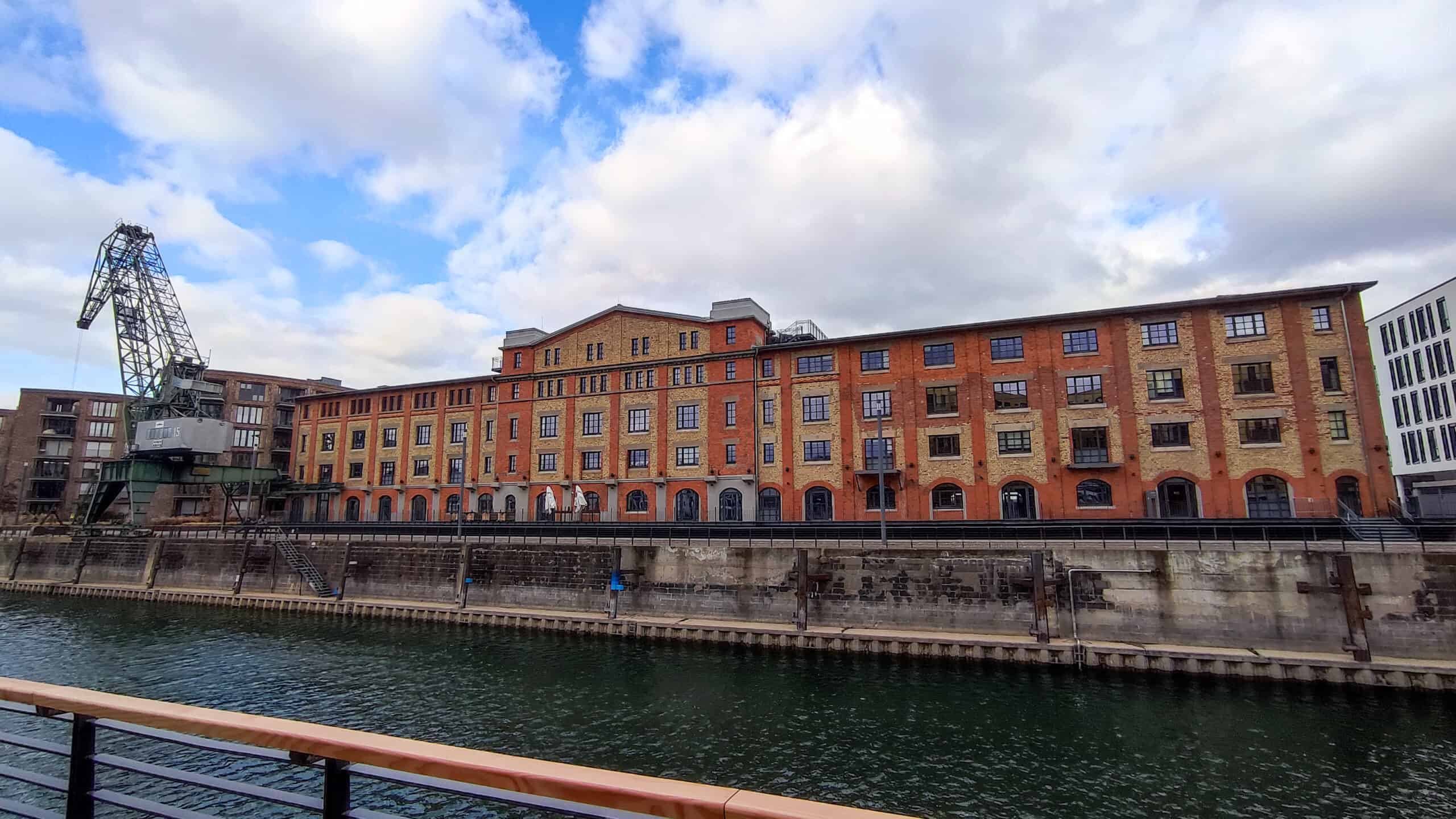 Ein Gebäude mit einem Kran am Ufer eines Flusses.